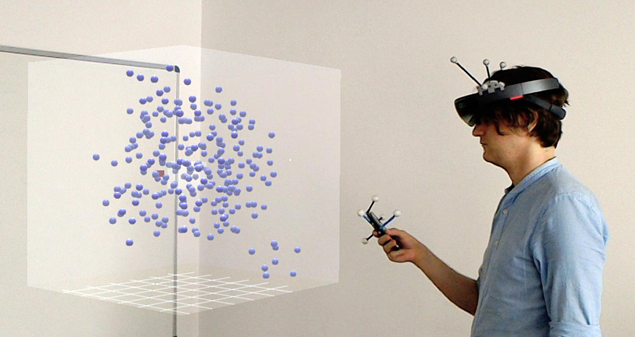 A photo of a user wearing a HoloLens and using a smartphone to explore an AR data set.