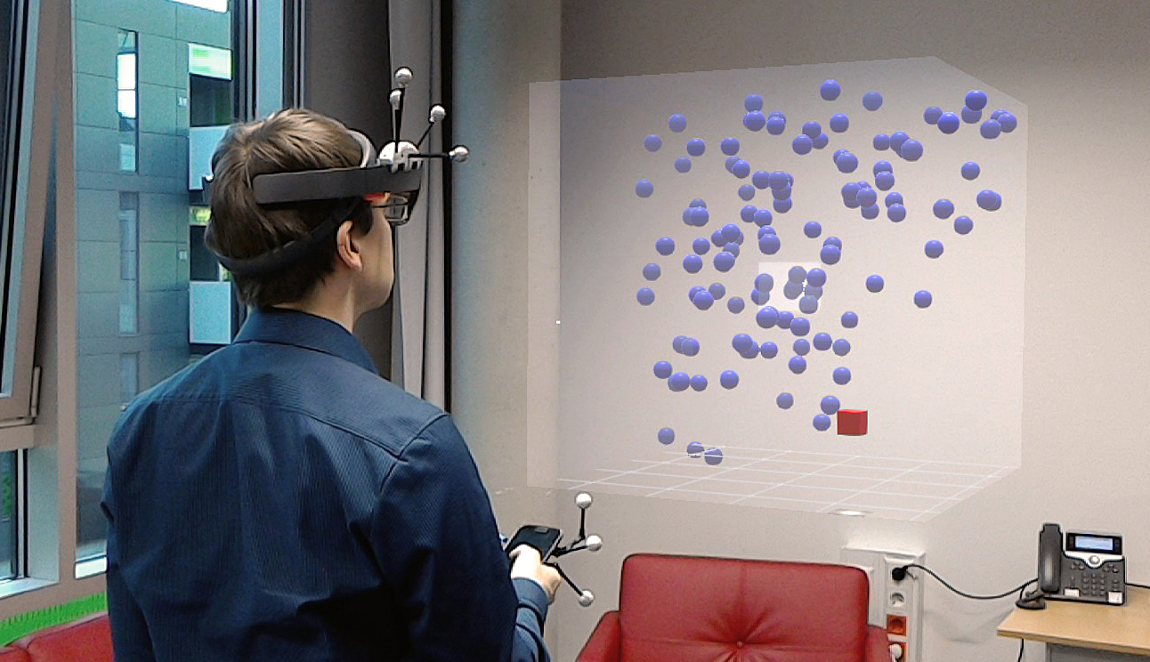 A photo of a user wearing a HoloLens and using a smartphone to explore an AR data set.